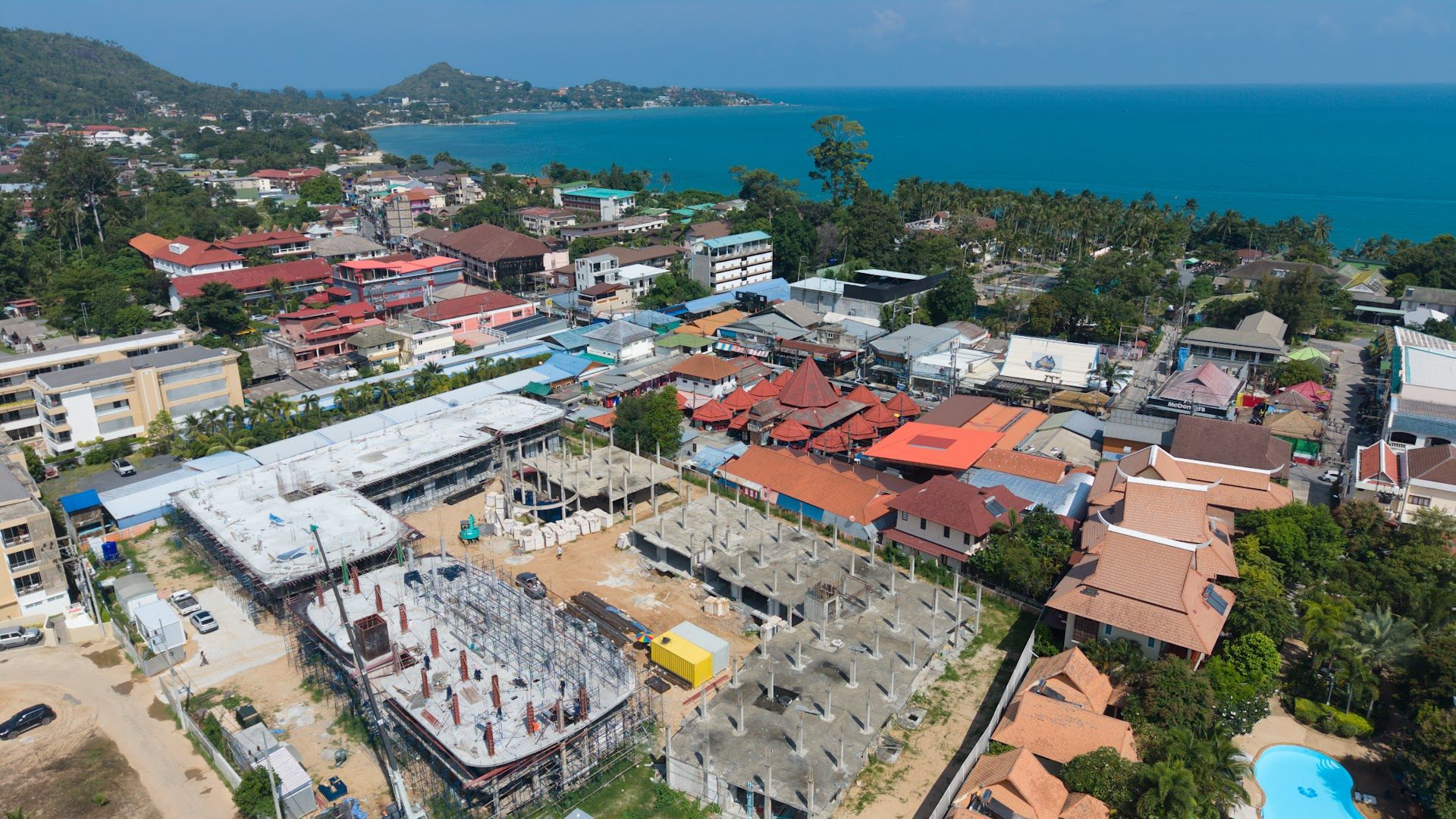 Aerial drone view of the Coral Condo Samui construction site in Lamai with the sea behind